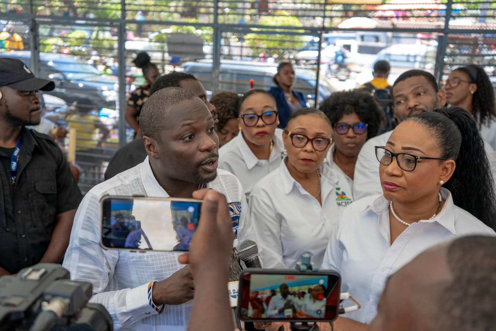 Le ministre du Commerce et de l'Industrie, James Monazard, entouré de journalistes au lycée national de Pétion-Ville.